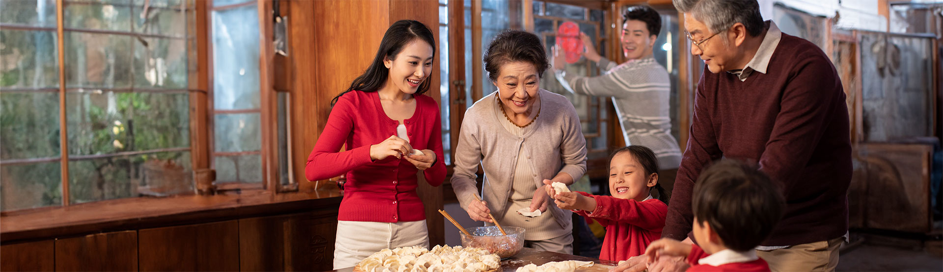 A Chinese family makes dumplings together in their home.