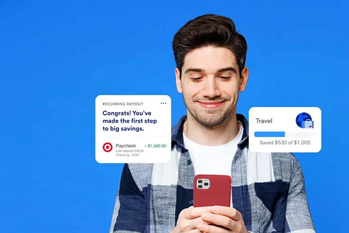 Smiling man holding mobile phone. Savings goal progress by recurring deposit.