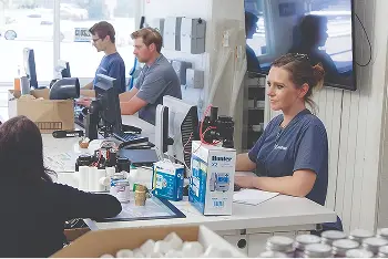 Woman working on computer in a busy office
