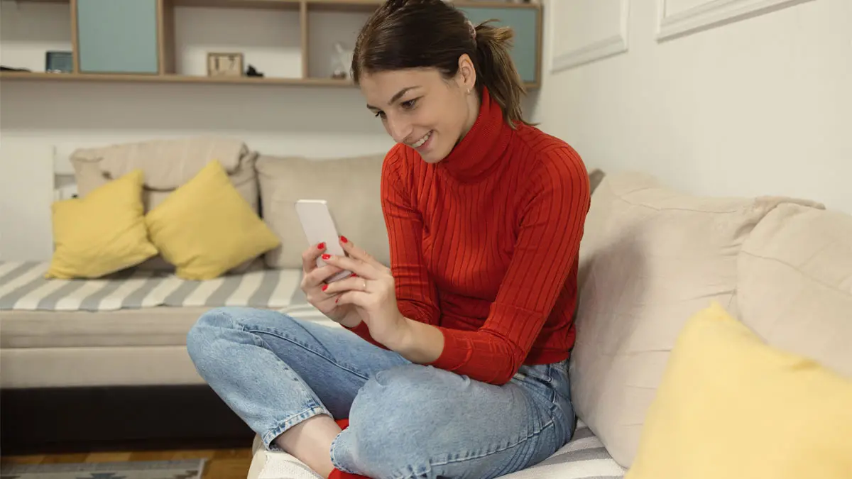Photo of woman on sofa looking at her phone
