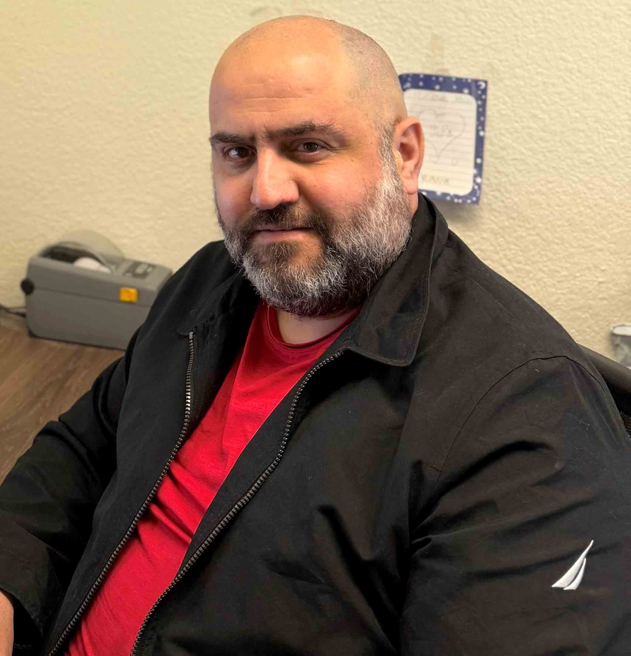 Man sitting at desk and facing camera