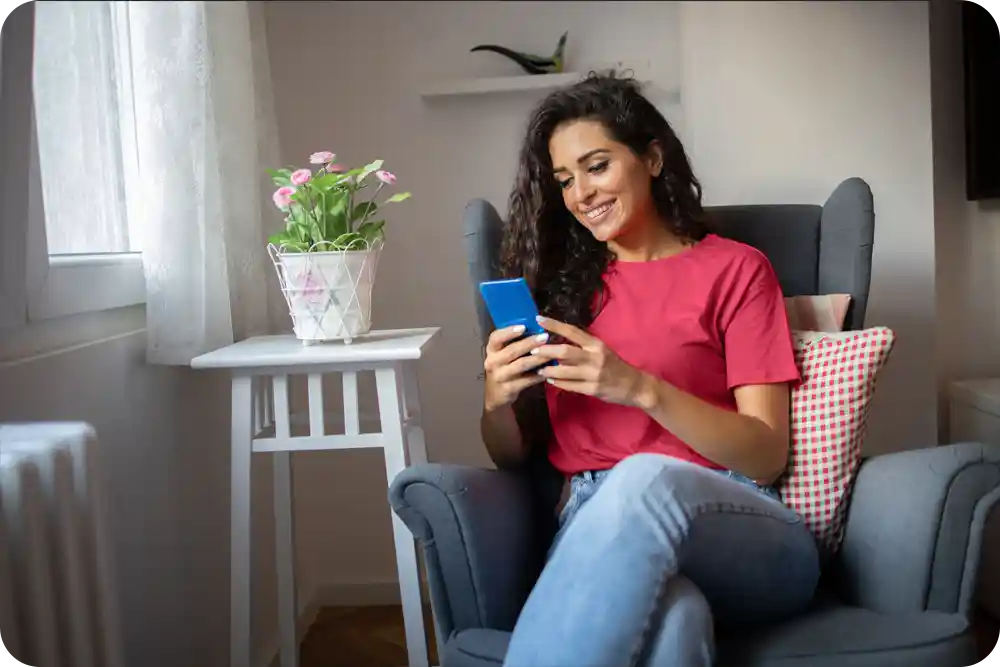 Woman sitting on sofa looking at her phone