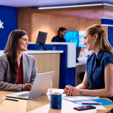 Una joven empresaria recibe ayuda de un representante bancario en una sucursal de U.S. Bank.