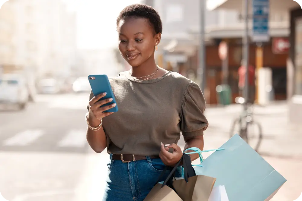 A woman walking and looking at her phone.
