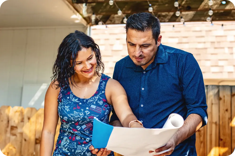 A man and woman reviewing blueprints.