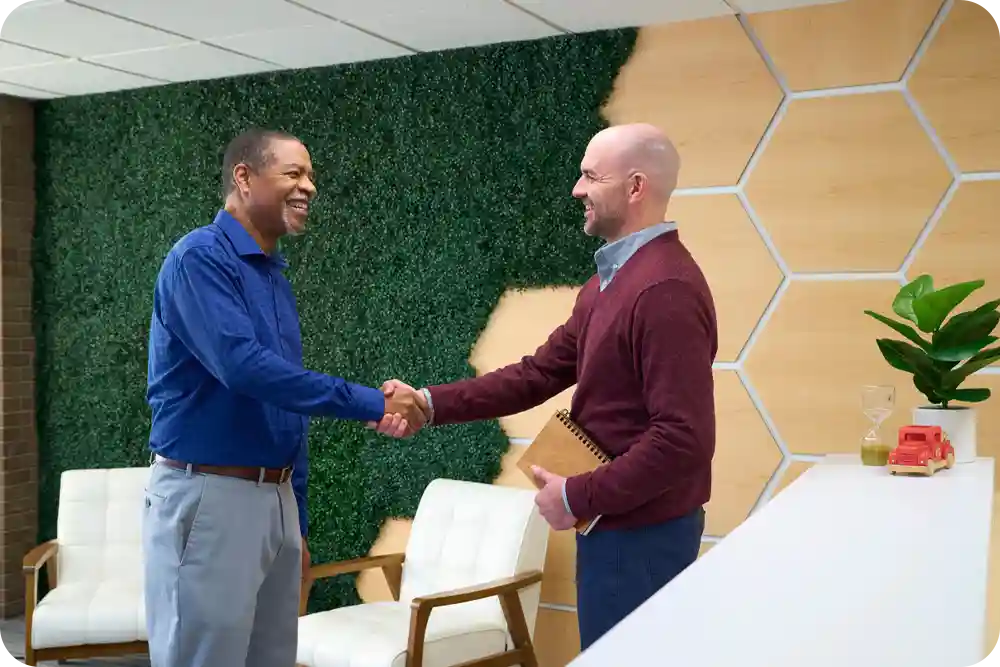 Two men in a business lobby shaking hands