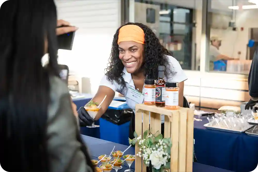Woman serving food to a customer at an outdoor event