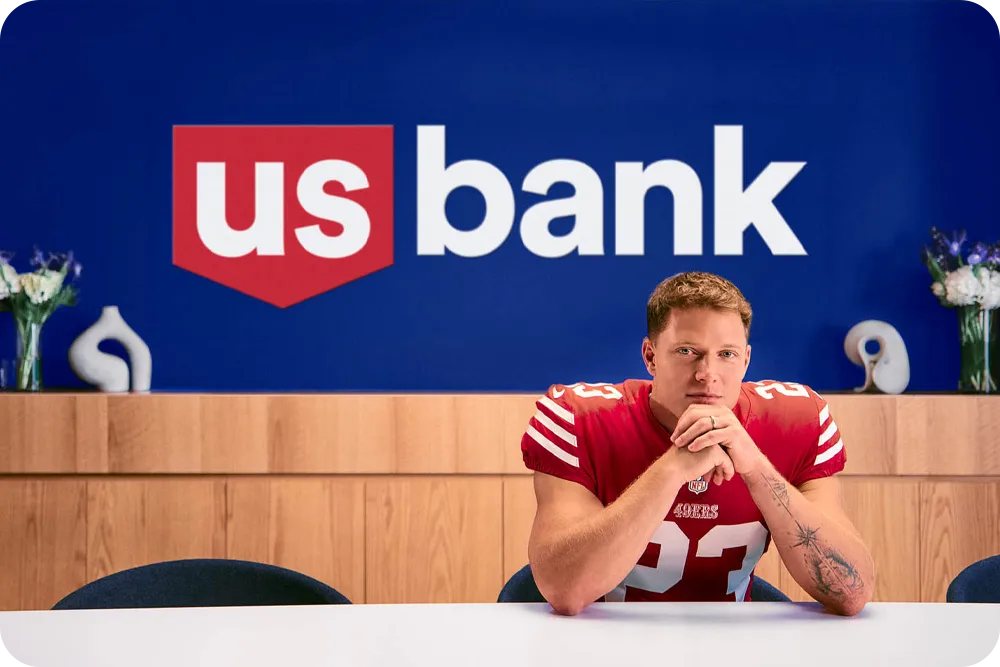 A man in a football uniform sitting at a table.