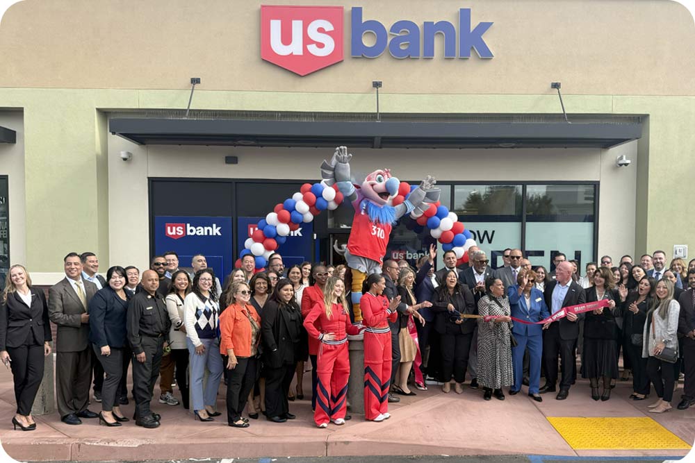 Photo of a large group of people in front of a balloon arch