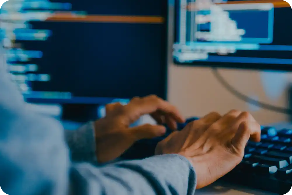 Hands typing on a computer keyboard.