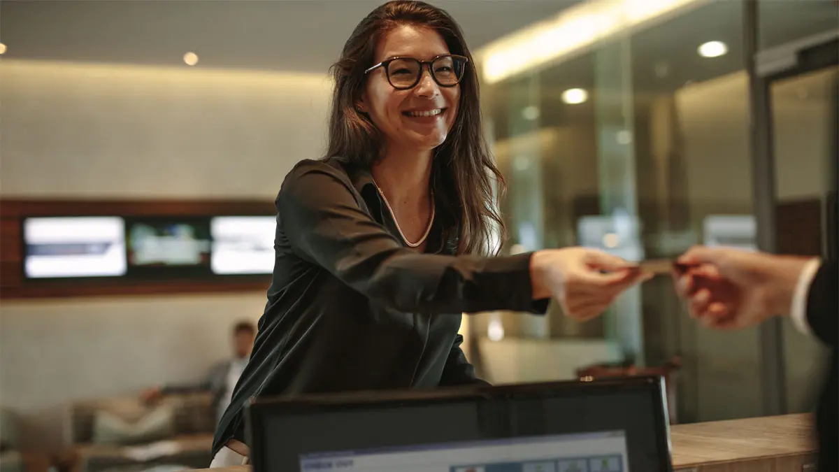Woman paying with a credit card at a hotel desk