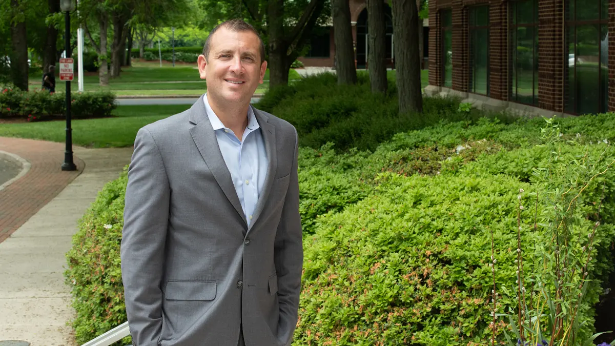 A man wearing business attire standing outside.