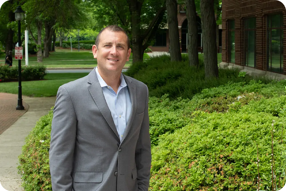Man wearing business attire standing outside.