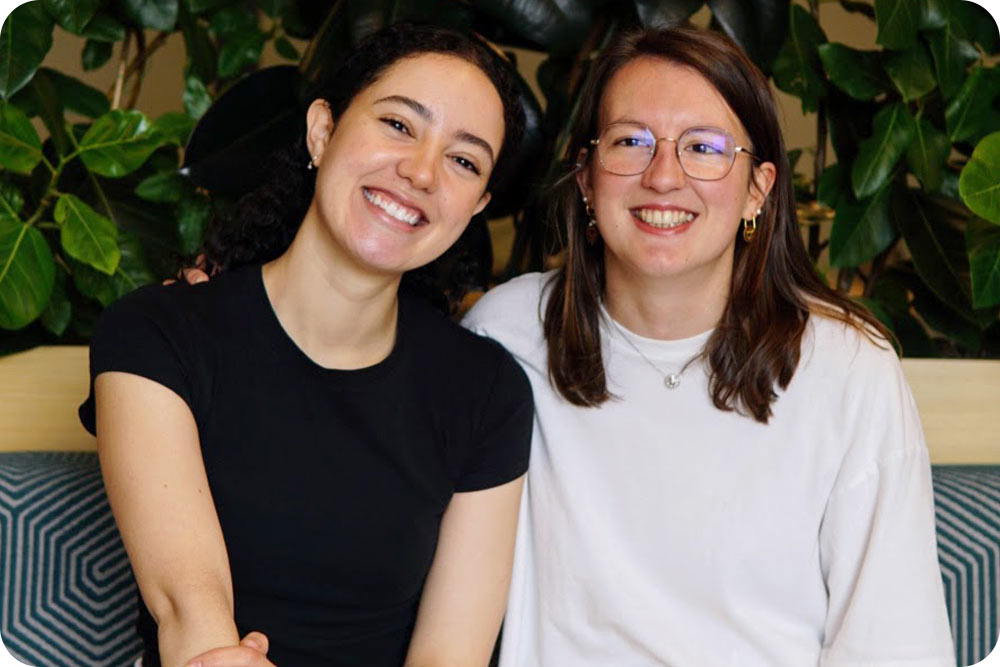 Two women sitting together and facing the camera.