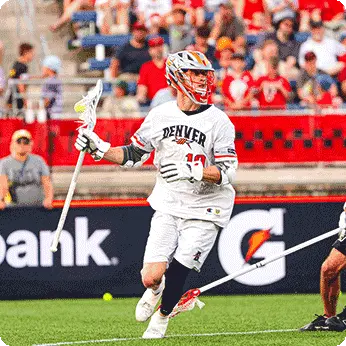 Denver Outlaws lacrosse player is running across the field.