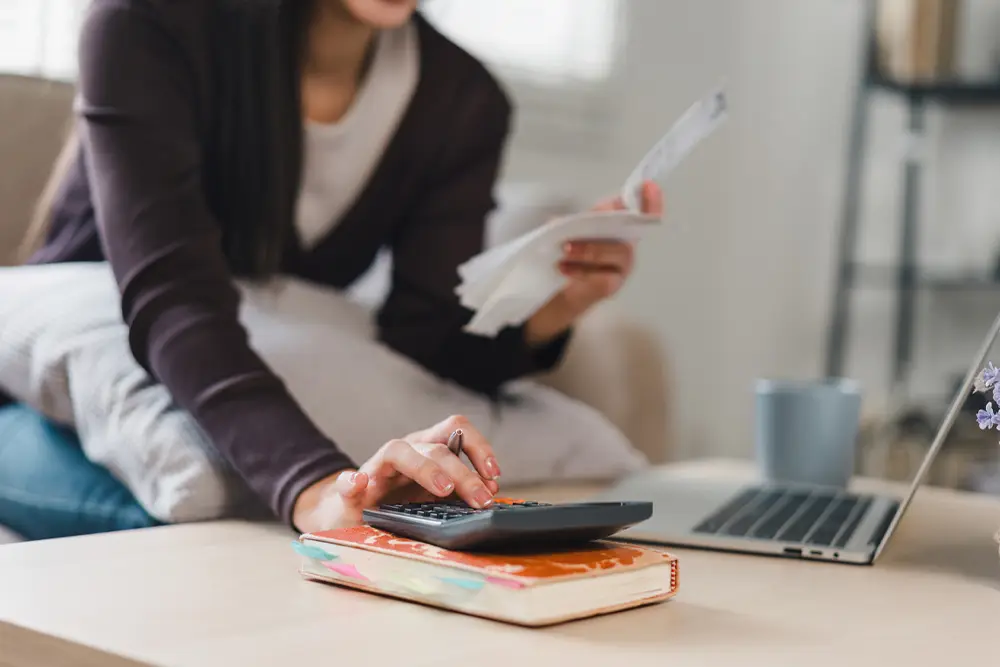 Woman with a laptop and calculator.