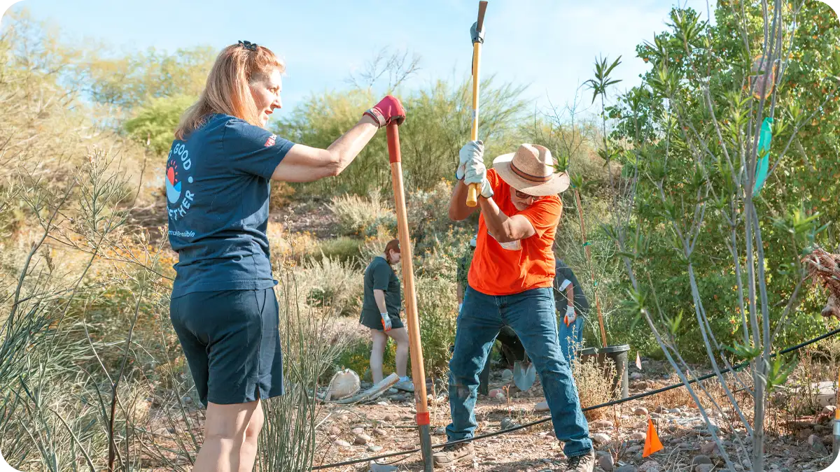 A man swinging a pickaxe at the ground.