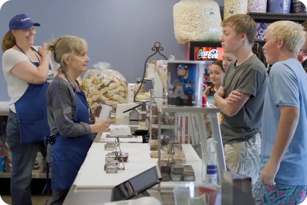 Workers and customers at a popcorn store.