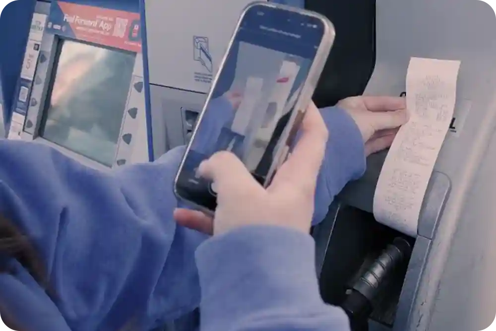Woman's hand as she takes a photo of her gas pump receipt