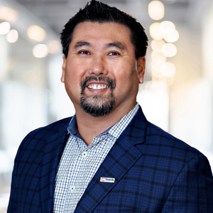 Headshot of a man wearing a blue suit