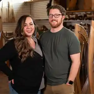 Husband and wife standing in front of harps.
