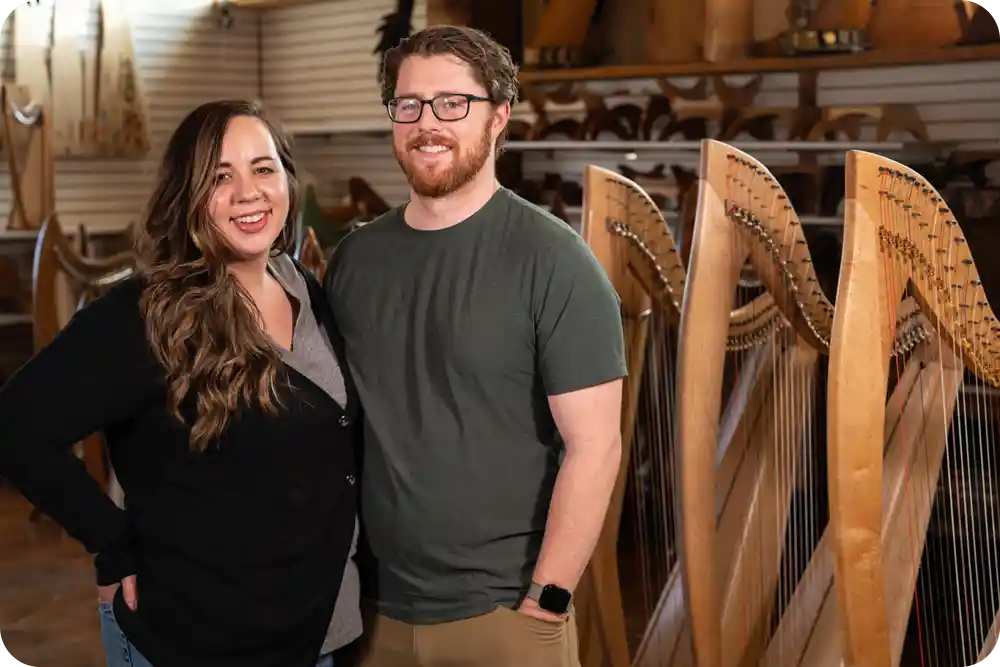 Man and woman in front of harps