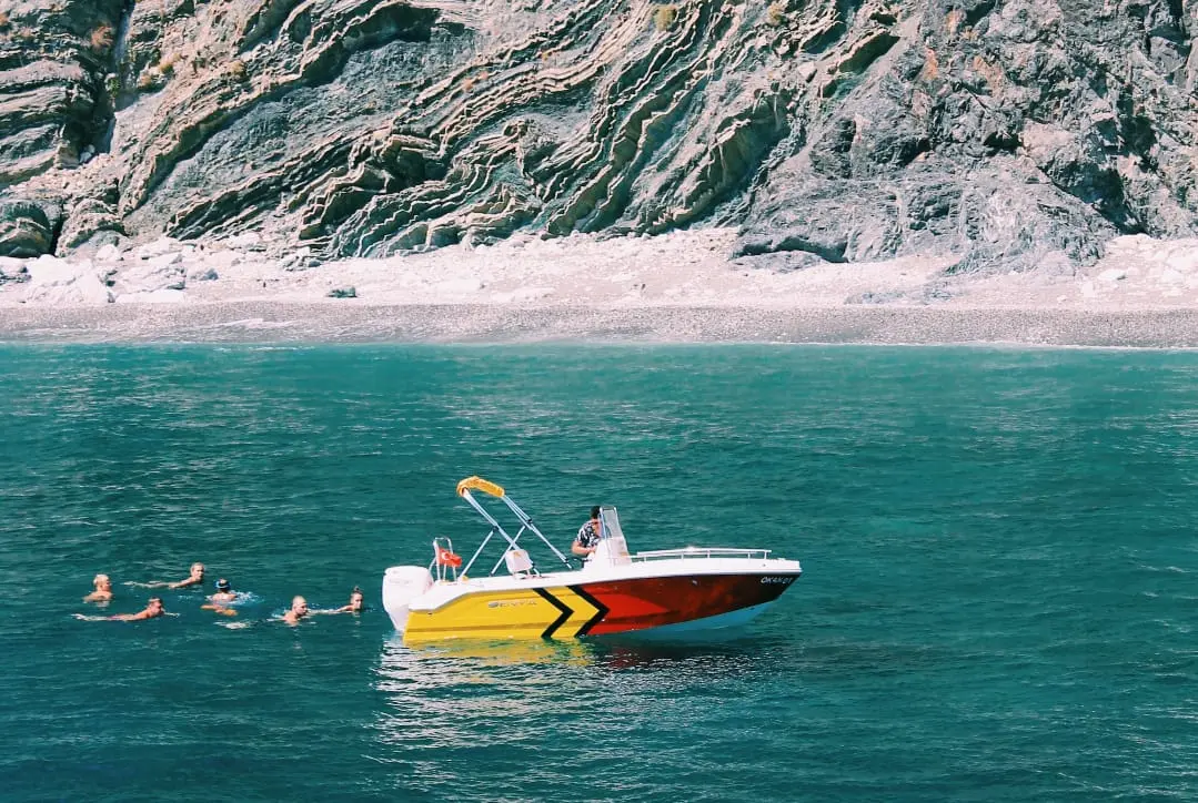Speed boat on the water with swimmers nearby