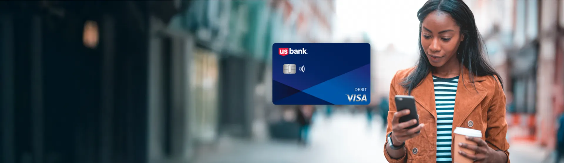 U.S. Bank debit card displayed prominently next to a consumer checking her phone