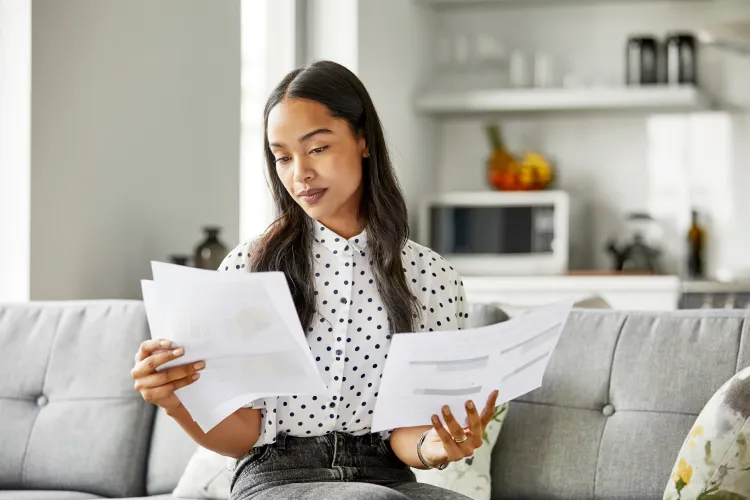 Photo of woman on couch reviewing documents