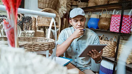Trabajador en una tienda de regalos viendo una tableta.