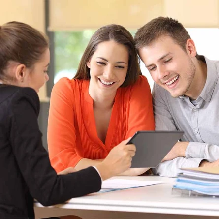 A man and woman are reviewing content together on a tablet, both focused and engaged in the discussion.