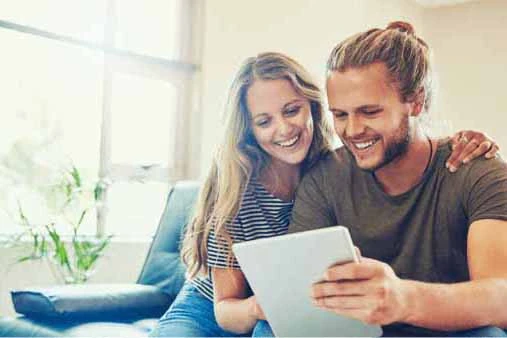 A couple enjoying time together, focused on a tablet screen while sharing ideas or information.