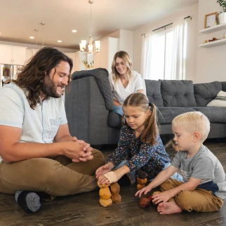 Family spends time together in a bright living room, reflecting the comfort and stability a rate-and-term refinance can help support at home.