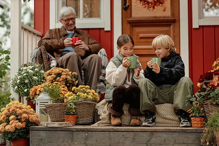 Image of grandfather and grand kids outside during autumn