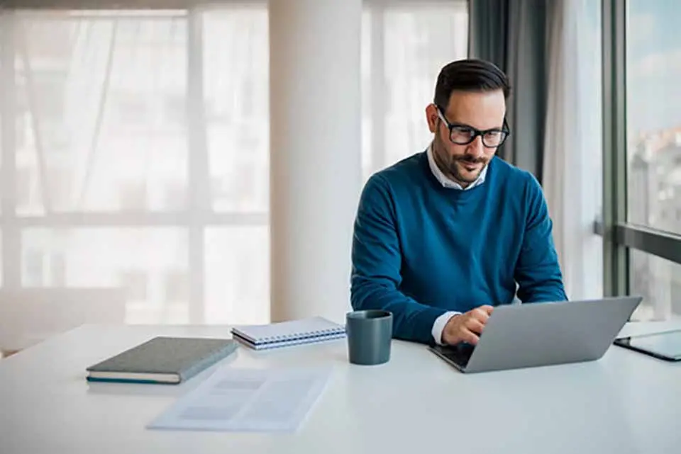 A man on his laptop analyzing housing market trends and data