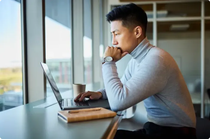 Man sitting in an office working on a laptop