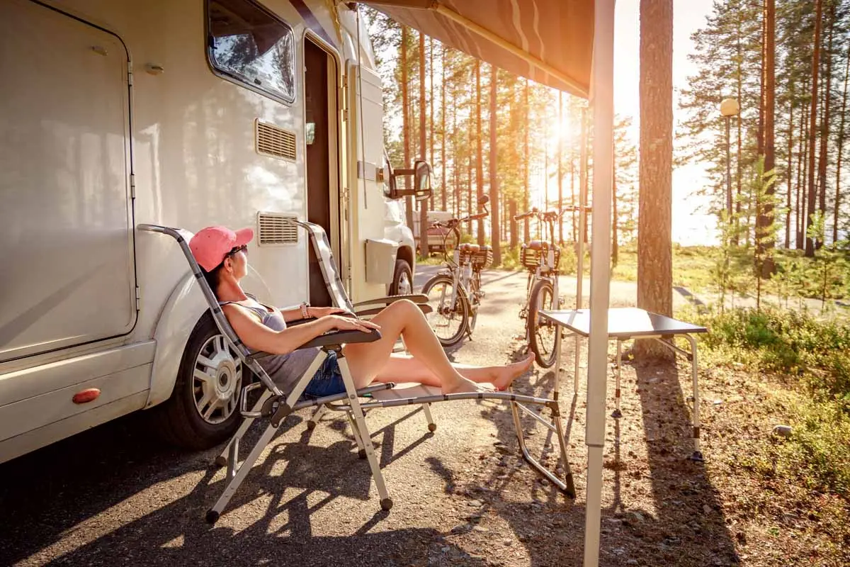Female camper relaxing in chair outside of RV