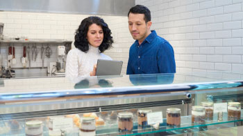 photo of two restaurant workers looking over food selection