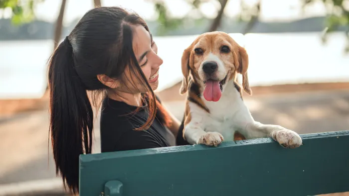 Woman with dog in park on bench