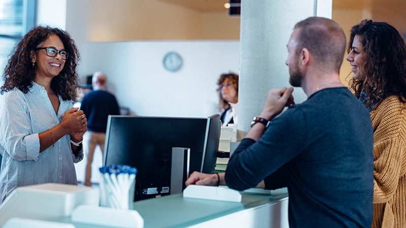 Couple talking to a DMV employee at the counter
