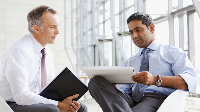 Two office colleagues discussing how to invest in the private credit market 