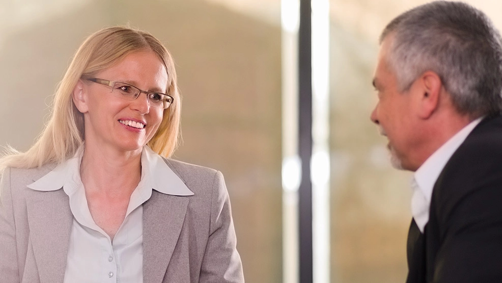 Businesswoman and man discuss solutions for their business journey in a meeting room. 