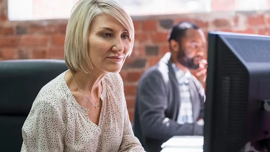 Woman in office looking at computer screen researching ways to improve the accounts payable process through automation.