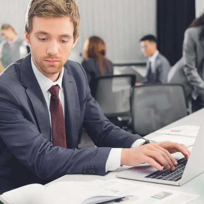 Man wearing a suit using a laptop to make a cross-border payment