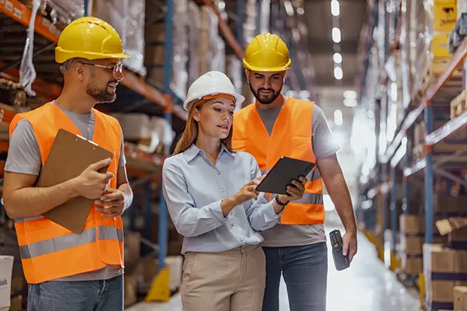 Female executive discussing supply chain resilience with warehouse workers