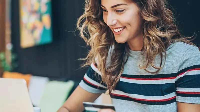 Woman making an online purchase through a platform that authenticates cardholder data to reduce payment fraud.