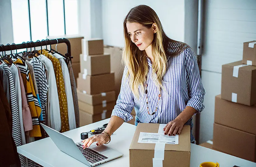 Image of a women on a computer and looking at a package