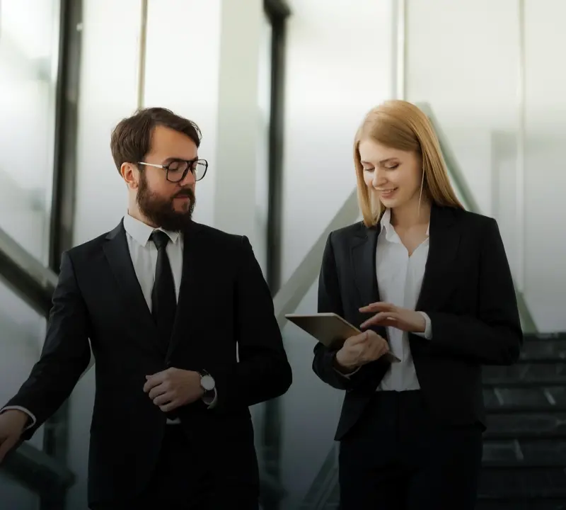 Professional man and woman in suits walking and talking