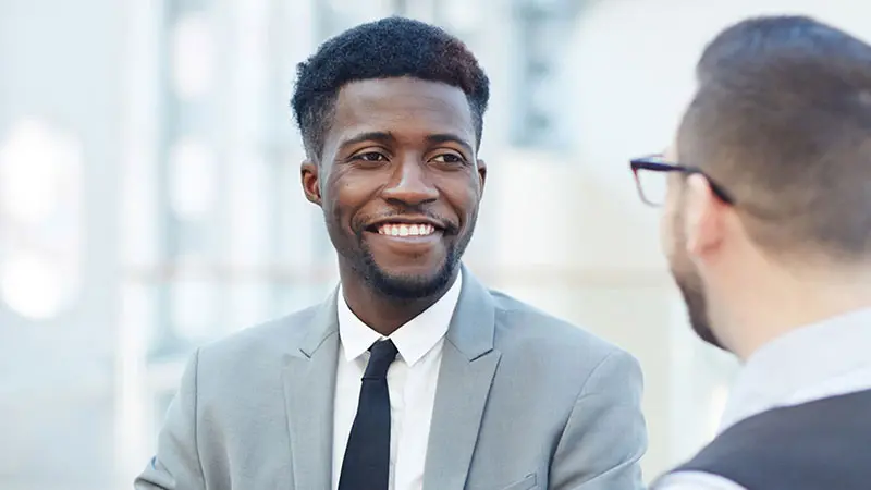 Two businessmen discuss fund servicing solutions.