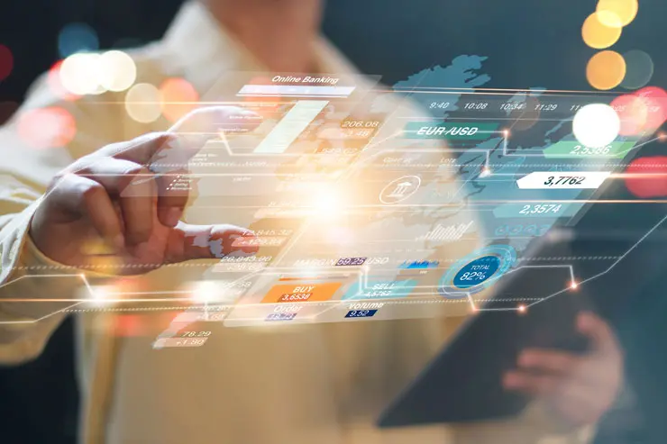 A woman using her hand to swipe through international market data on a large screen
